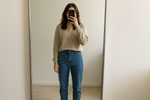 haz una mujer tomandose foto en el espejo donde se le ve el cuerpo pero la cara se la tapa con el celular